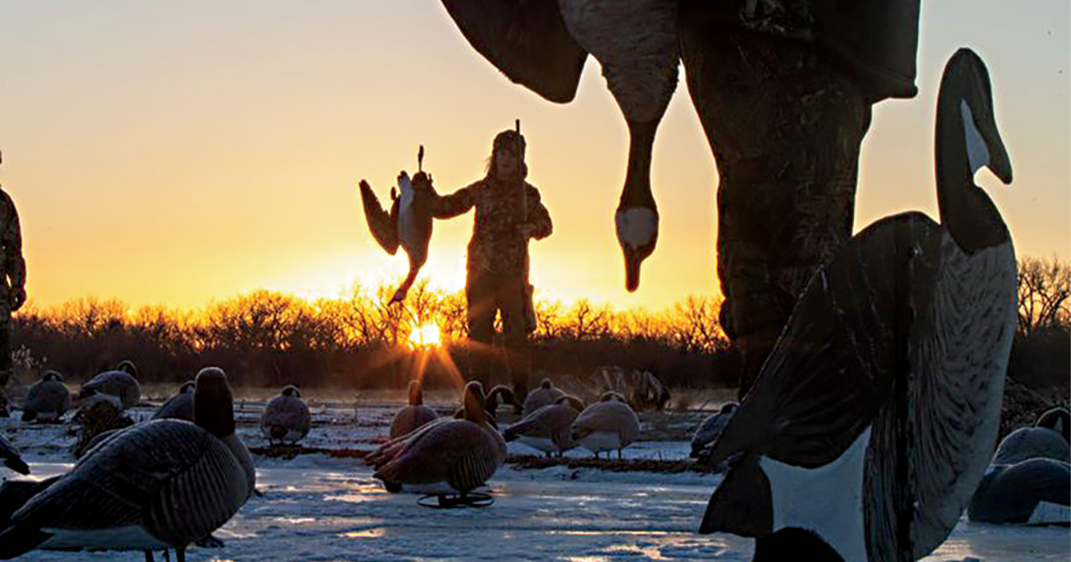 Hunters in decoys holding harvested goose. Photo by DougSteinkePhotos.com.jpg